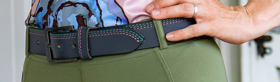 Person wearing a green belt with a colorful top and pink shirt.