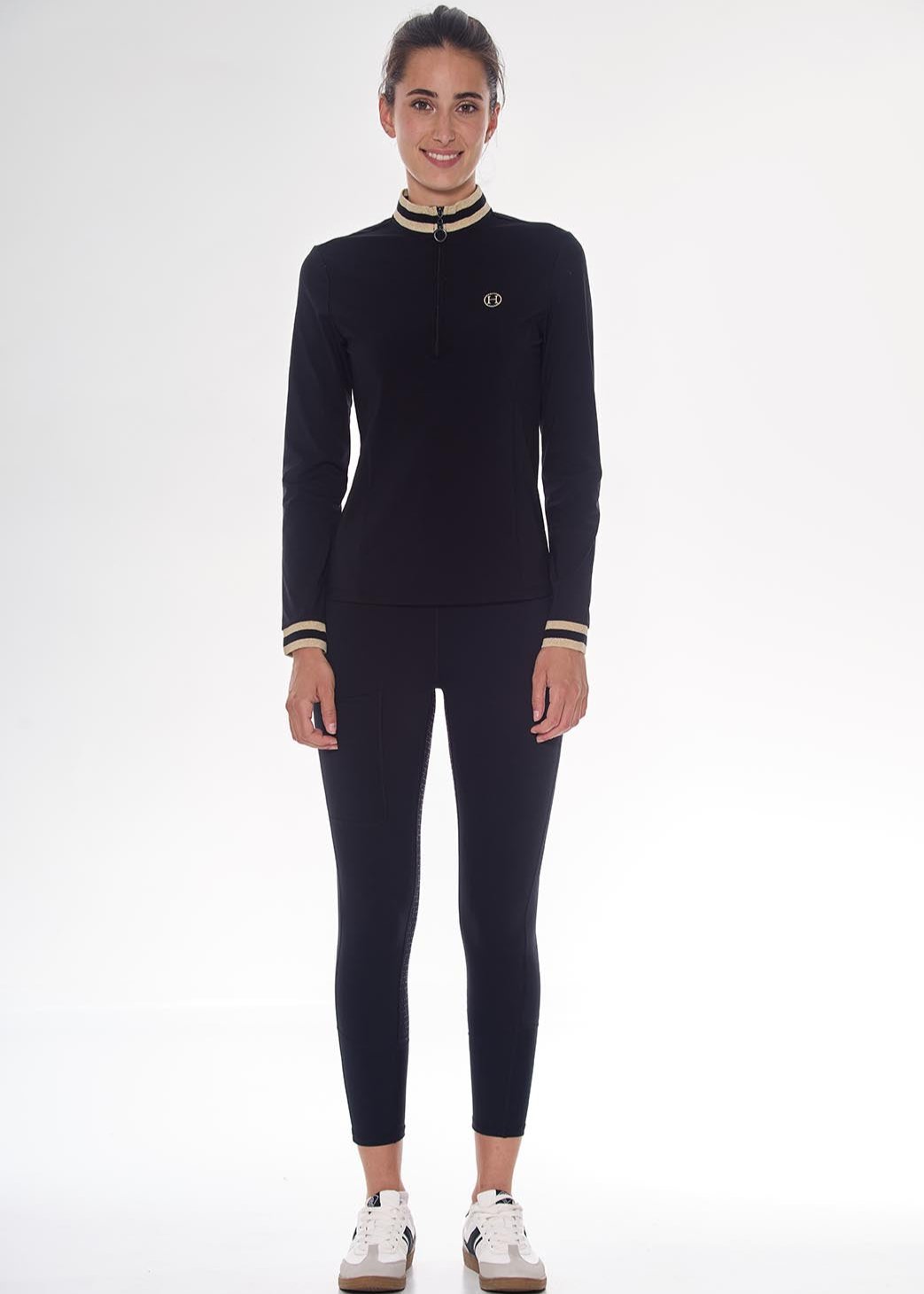 Woman wearing a black outfit with white accents on a white background