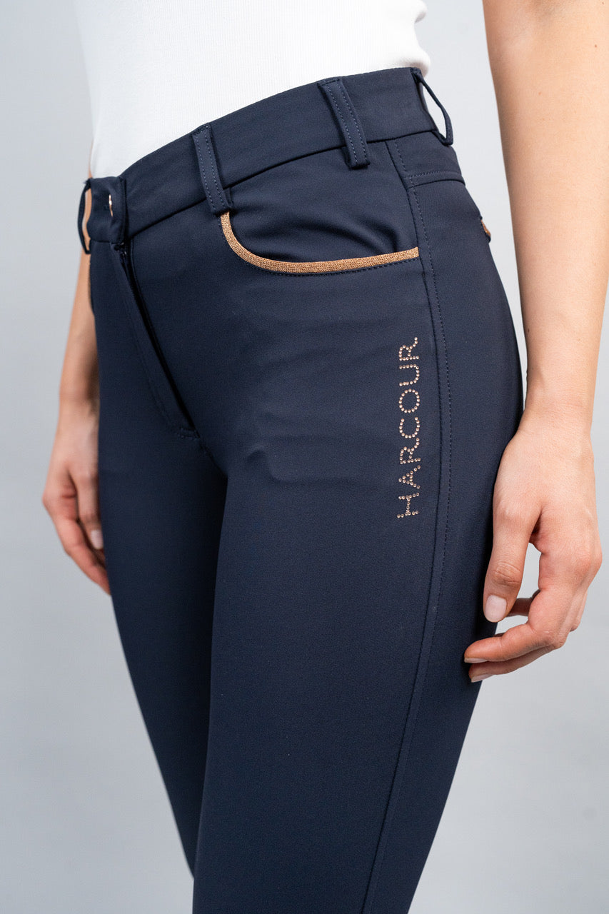 Navy riding pants with 'Harcour' branding on a gray background