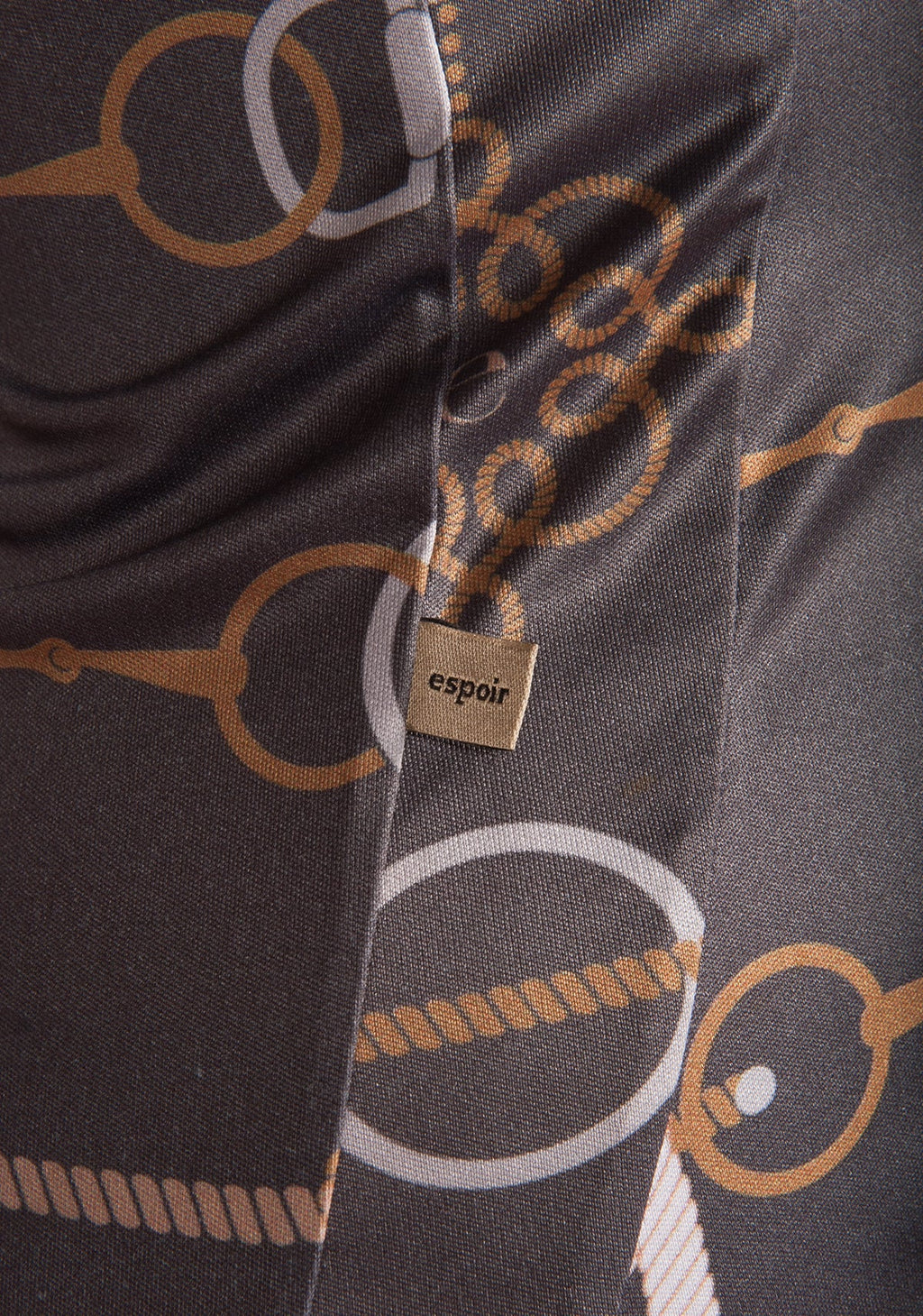 Close-up of a patterned fabric with 'espoir' brand tag, featuring circular and oval shapes.