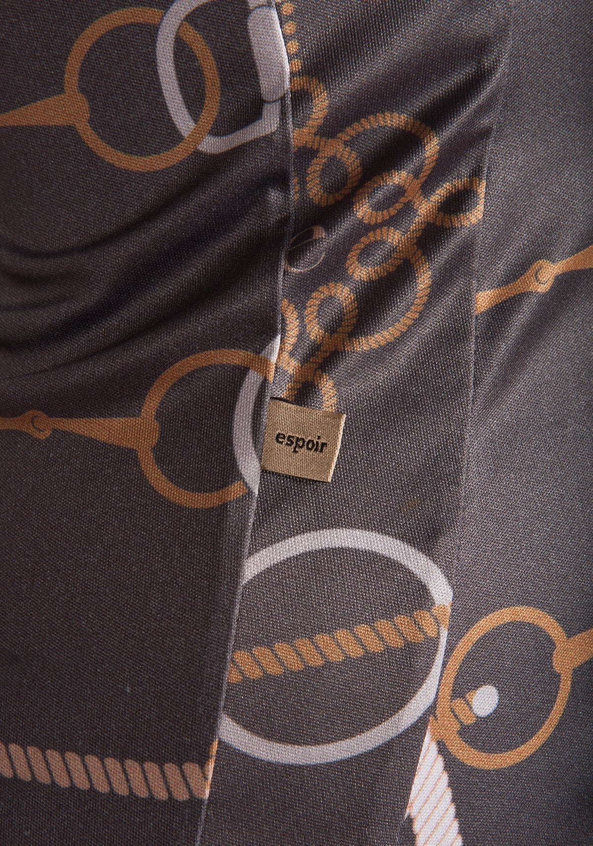 Close-up of a patterned fabric with 'espoir' brand tag, featuring circular and oval shapes.