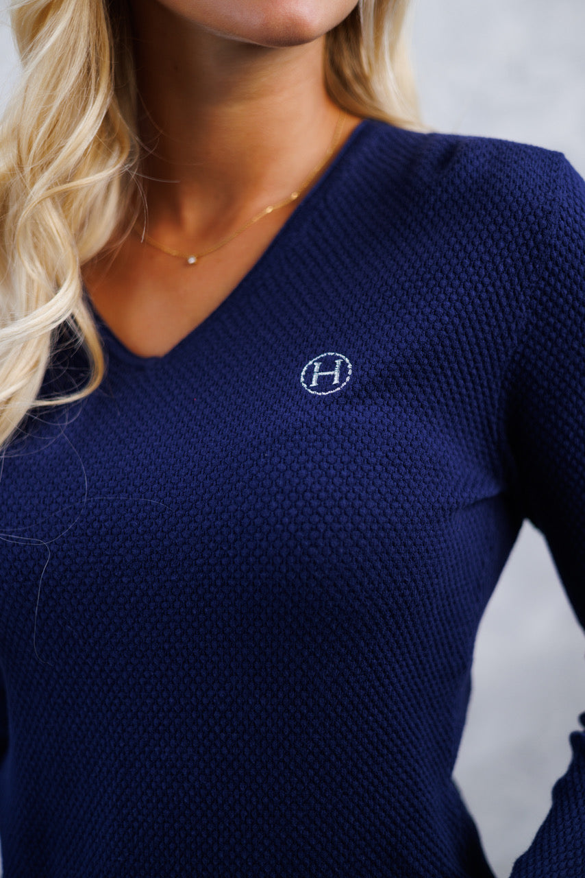 Navy blue long-sleeve top with a logo on the chest against a neutral background
