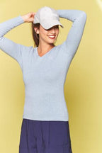 Woman wearing a light blue sweater and white cap against a yellow background